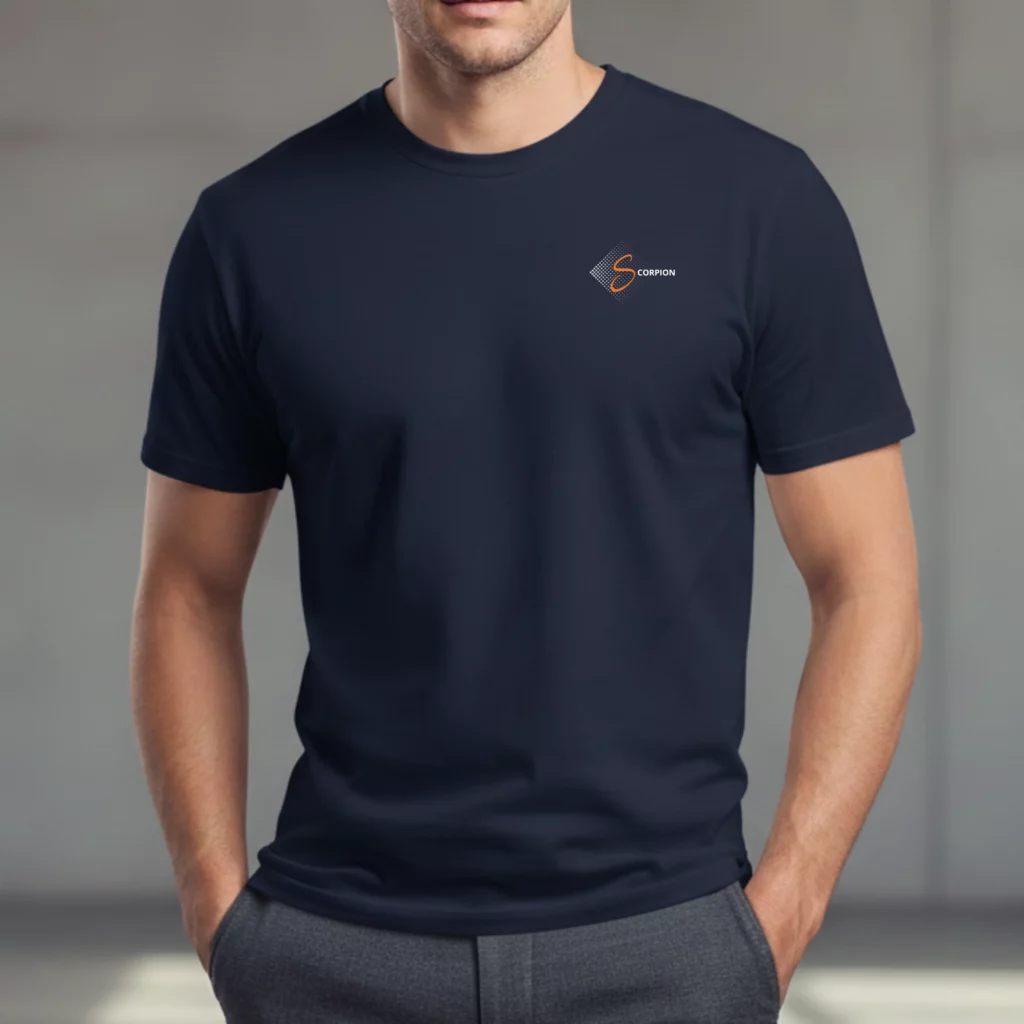 L'astrologie au masculin : 3 tee-shirts pour porter son signe avec caractère Un homme portant un t-shirt bleu marine à manches courtes et col rond. Sur le côté gauche de la poitrine se trouve un logo discret composé d'un losange graphique gris, d'une lettre "S" orange stylisée et du mot "SCORPION" en blanc. L'homme porte un pantalon gris et a les mains dans les poches.