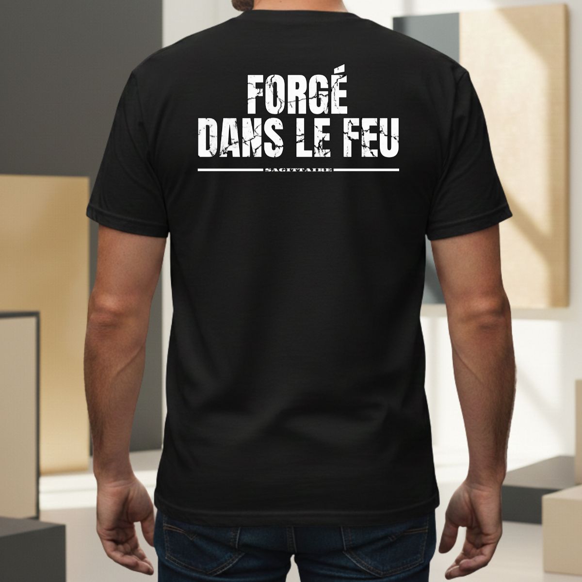 T-shirt Manches Courtes | Forgé dans le Feu | Sagittaire : Élément FEU T-shirt noir pour homme avec mention 'sagittaire' soulignée. Design graphique au style usé/vintage centré dans le dos, porté par un modèle masculin dans un cadre extérieur moderne.
