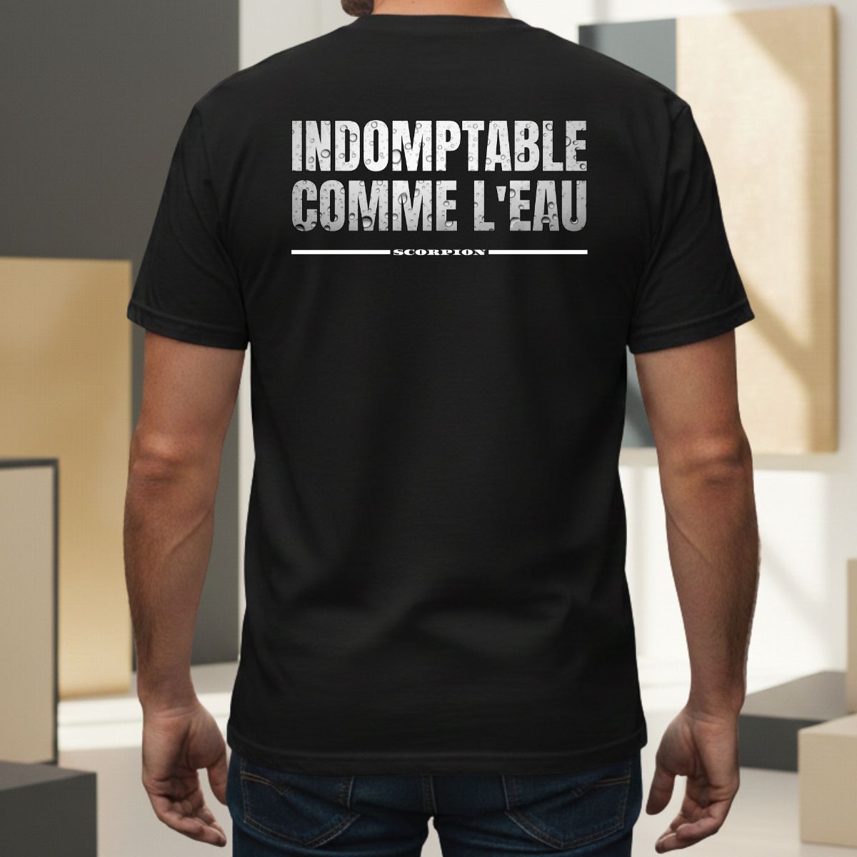 T-shirt Manches Courtes | Indomptable comme l'Eau | Scorpion : Élément EAU T-shirt noir pour homme avec mention 'scorpion' soulignée. Design graphique au style usé/vintage centré dans le dos, porté par un modèle masculin dans un cadre extérieur moderne.