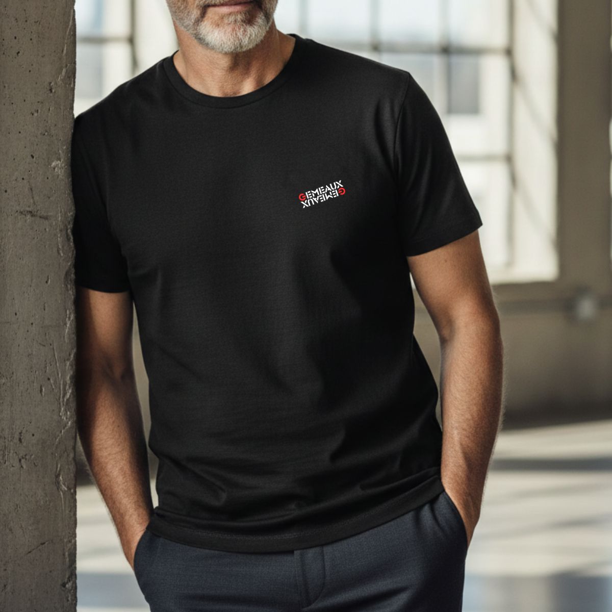 T-shirt Signe Astrologique Gémeaux | Imprimé Miroir Blanc & Rouge Homme mûr à barbe grisonnante portant un t-shirt noir, inscription du signe du zodiaque blanc et rouge "Gémeaux" avec effet miroir inversé.