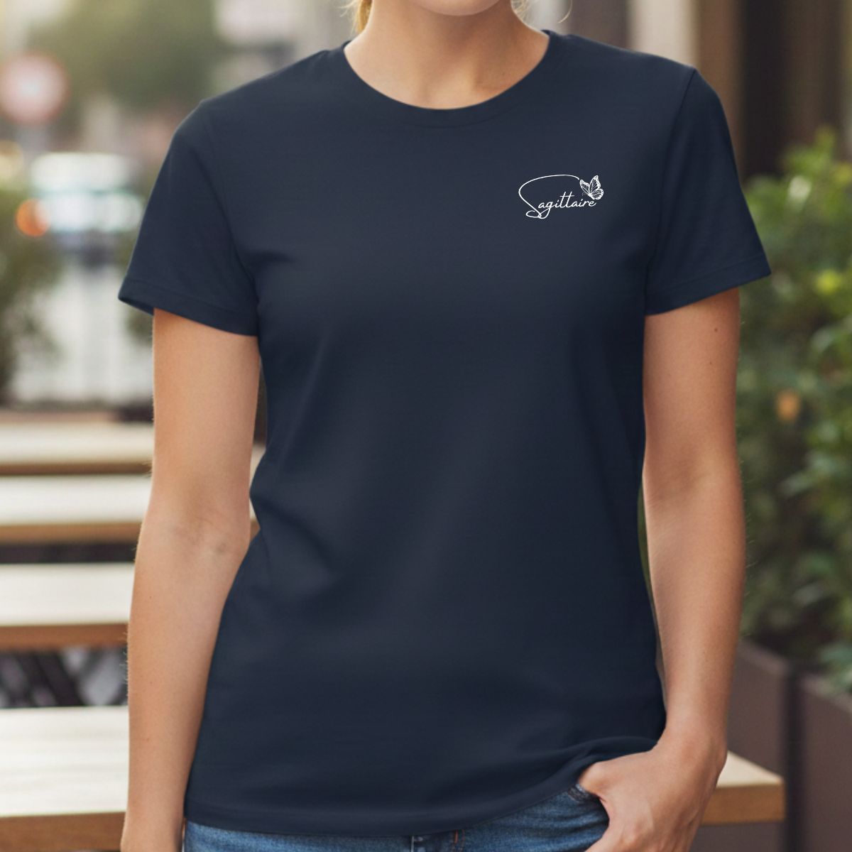 T-shirt Signe Astrologique Sagittaire & Papillon pour Femme T-shirt bleu marine pour femme avec motif "Fineline" blanc combinant l'inscription "Sagittaire" et un papillon délicat sur la poitrine, porté dans un style décontracté-féminin en terrasse.