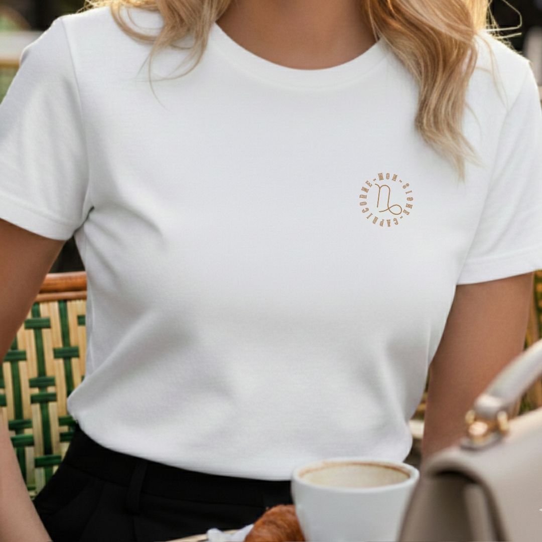 T-shirt blanc 100% coton avec motif médaillon circulaire or vieilli du signe capricorne, coupe semi-ajustée et col rond.