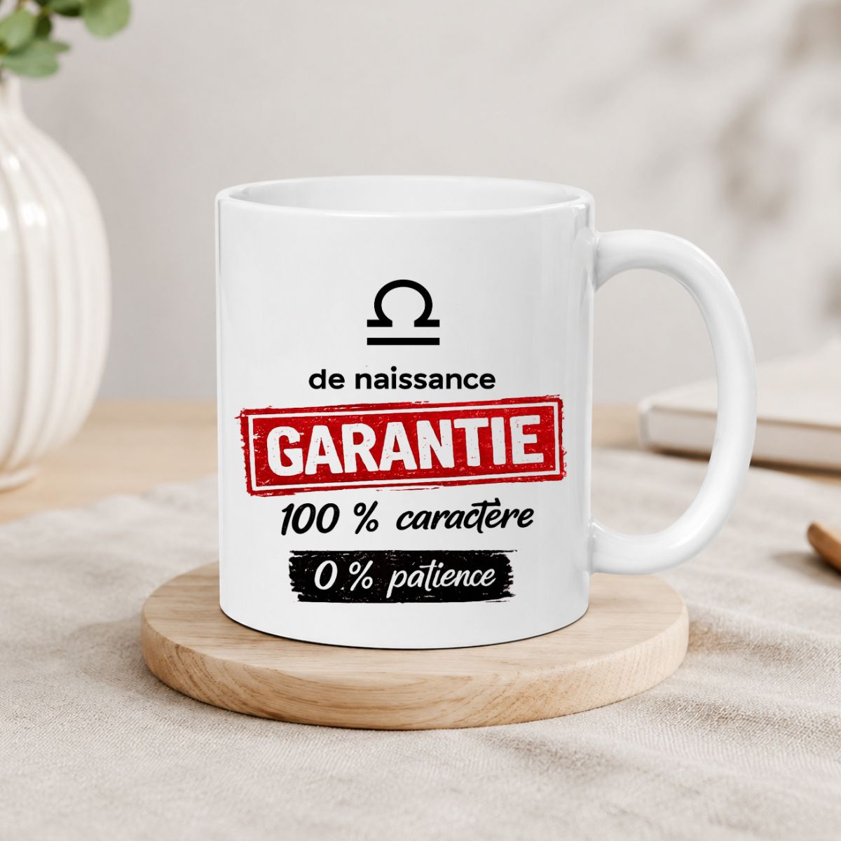Mug humoristique Balance - Garantie 100 % caractère, 0 % patience Mug humoristique Balance « Garantie 100 % caractère, 0 % patience » présenté sur un sous-verre en bois dans une ambiance chaleureuse. Création par Whizaloo.